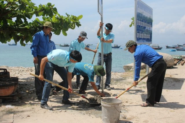 Các đồng chí cán bộ, đoàn viên, sinh viên cắm bảng tuyên truyền bảo vệ môi trường tại Đảo Thanh niên Nhơn Châu